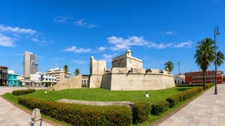The stone Baluarte de Santiago fort and palm-lined plaza under a blue sky in Veracruz, Mexico