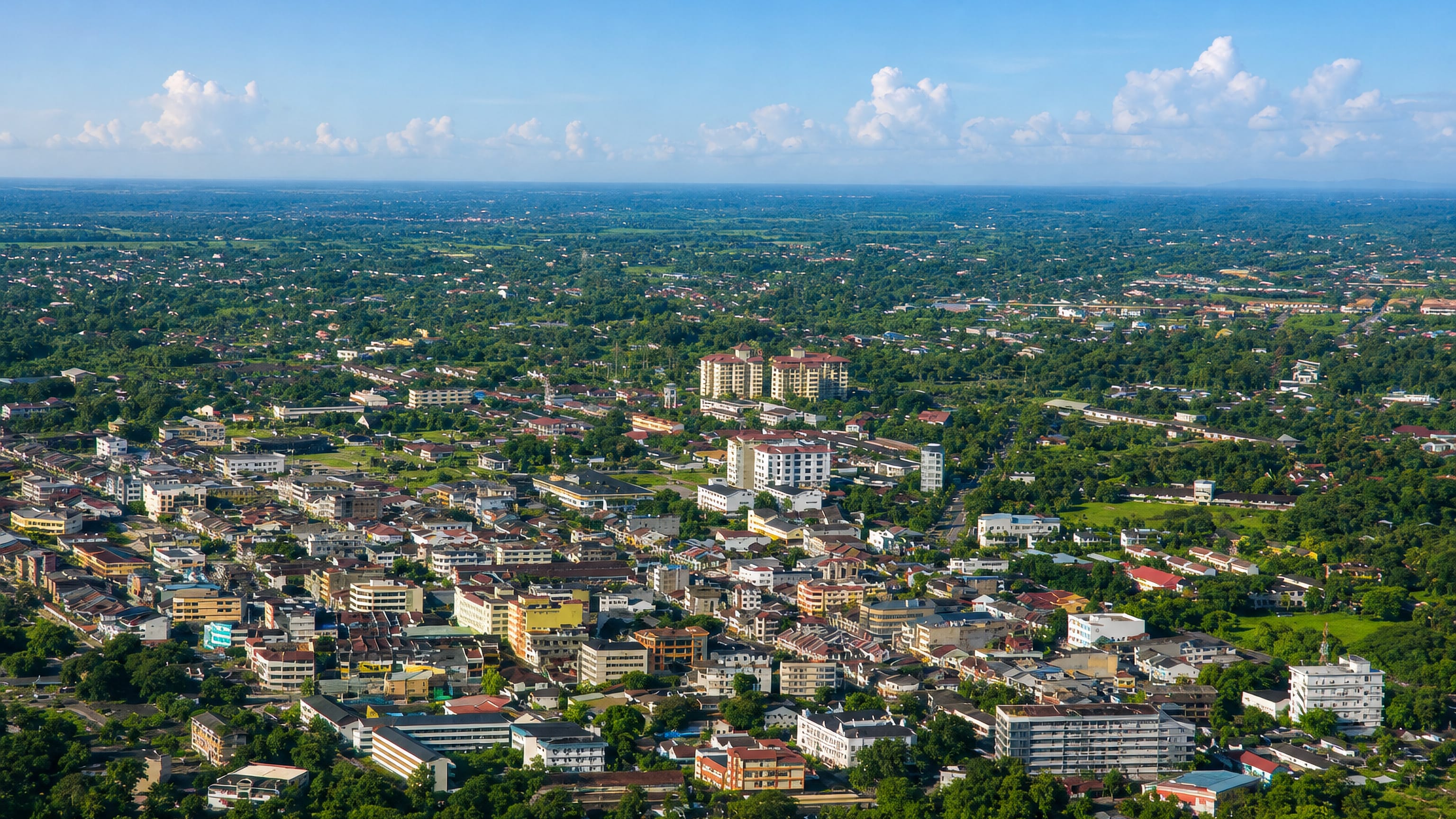 Aerial view over the low-rise, tree-filled town of Taiping, Perak, stretching across the coastal plain.