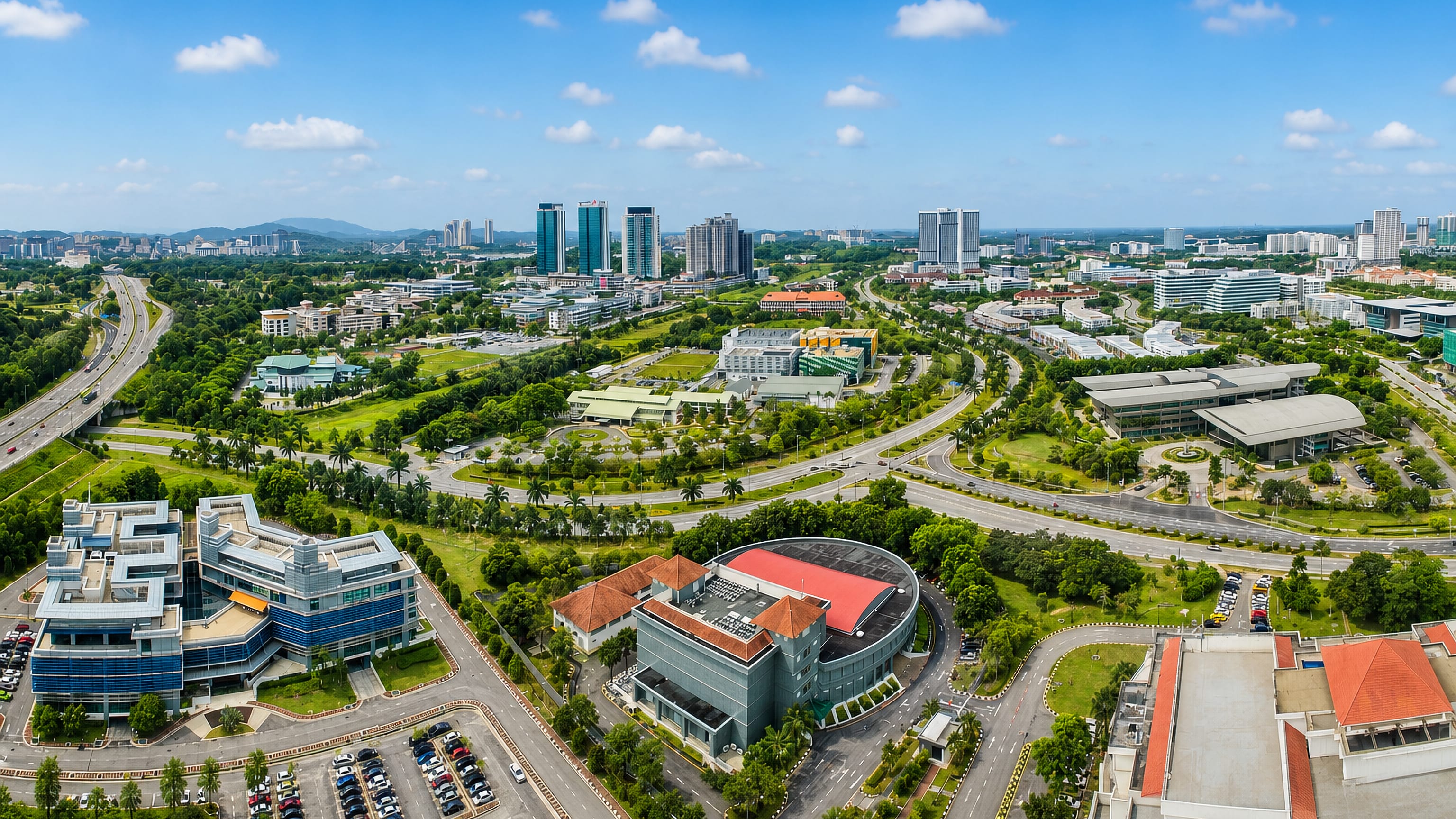 Landscaped boulevards and glass office campuses of Malaysia's planned tech city Cyberjaya from above.