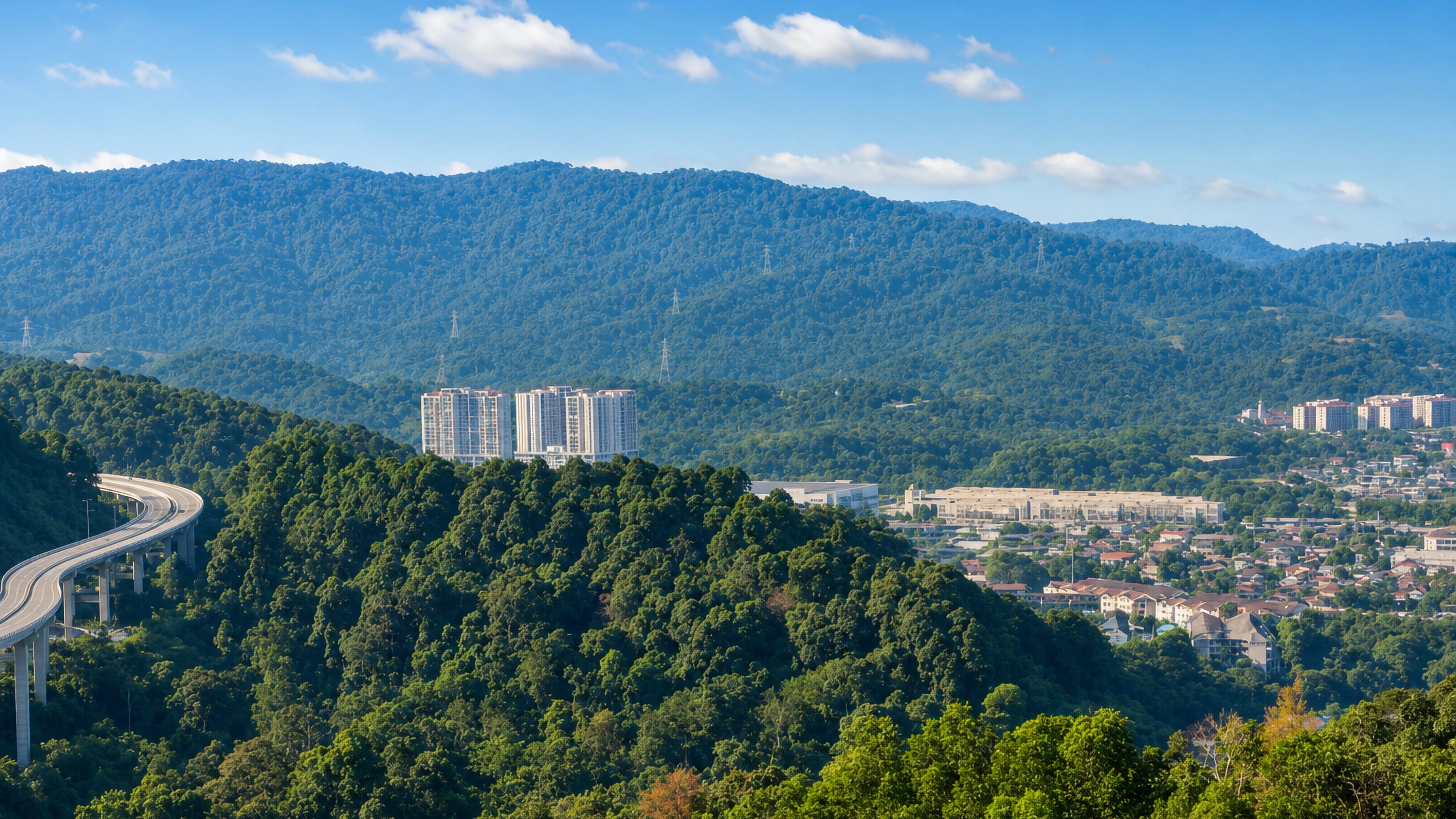 Elevated highway curving through forested hills above the town of Rawang, Selangor, Malaysia.