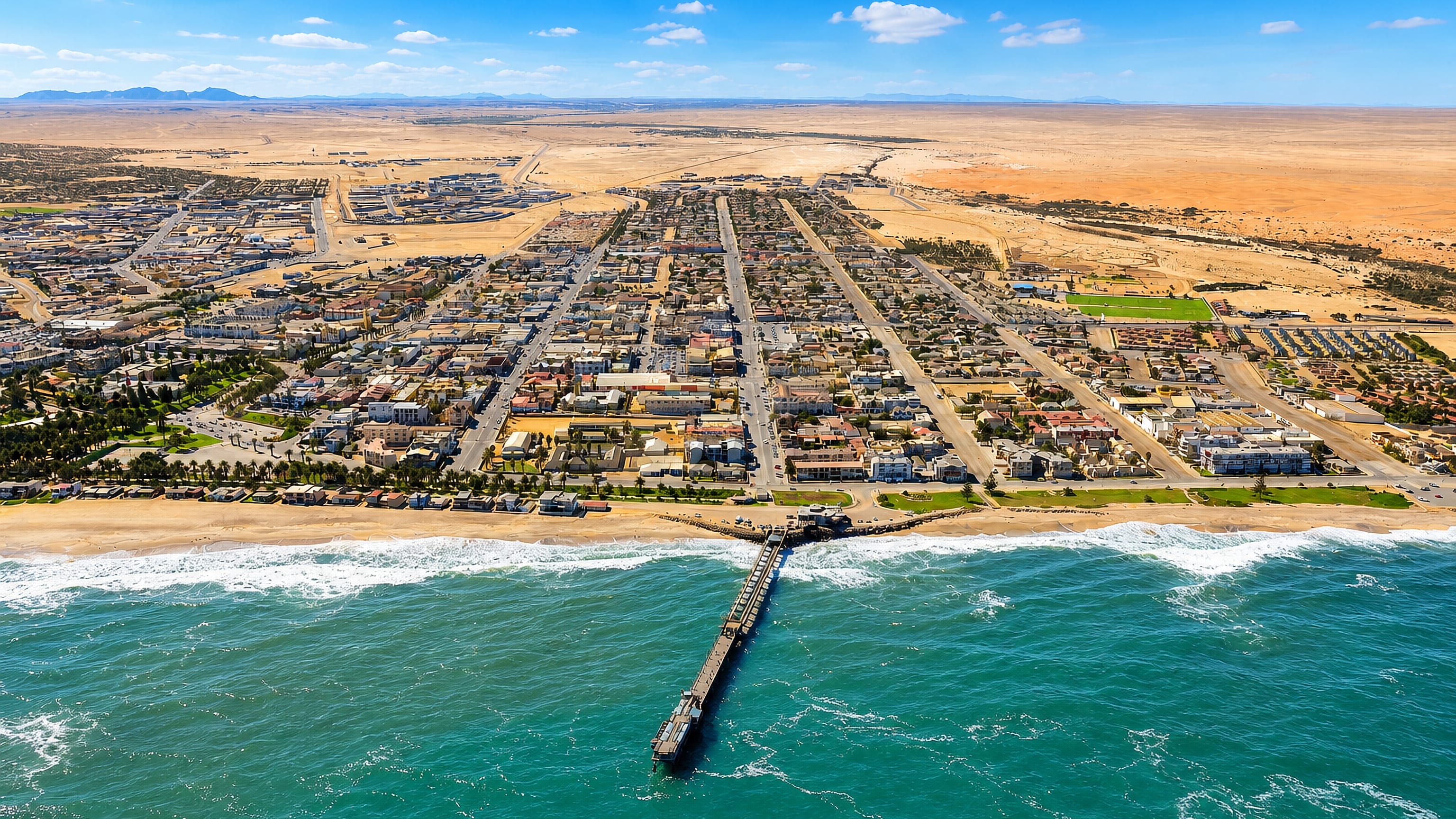 Swakopmund's jetty reaching into the Atlantic, with the Namibian town and Namib Desert stretching behind.