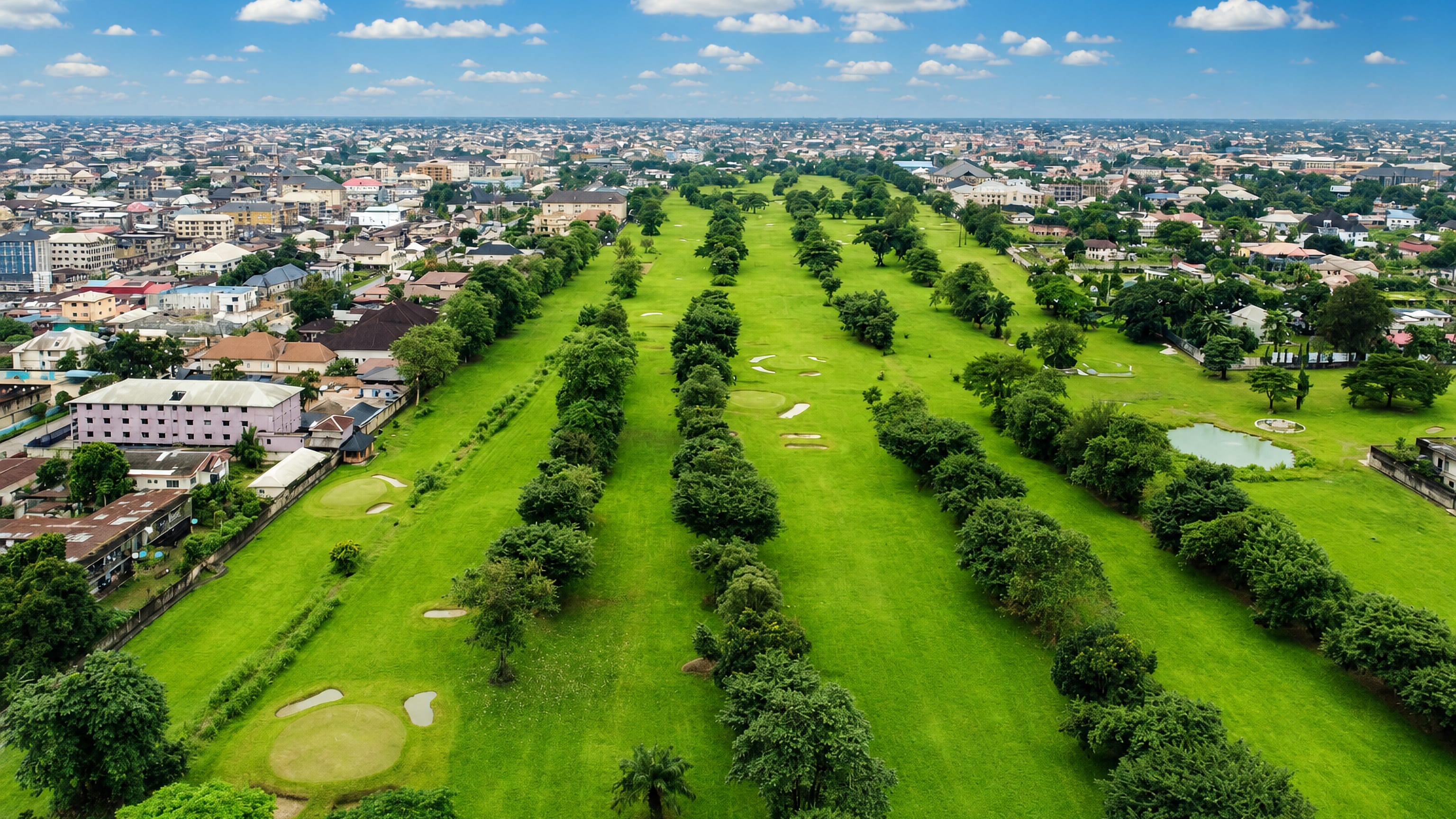 Aerial view over a green golf course ringed by the dense rooftops of Aba, Abia State, Nigeria.
