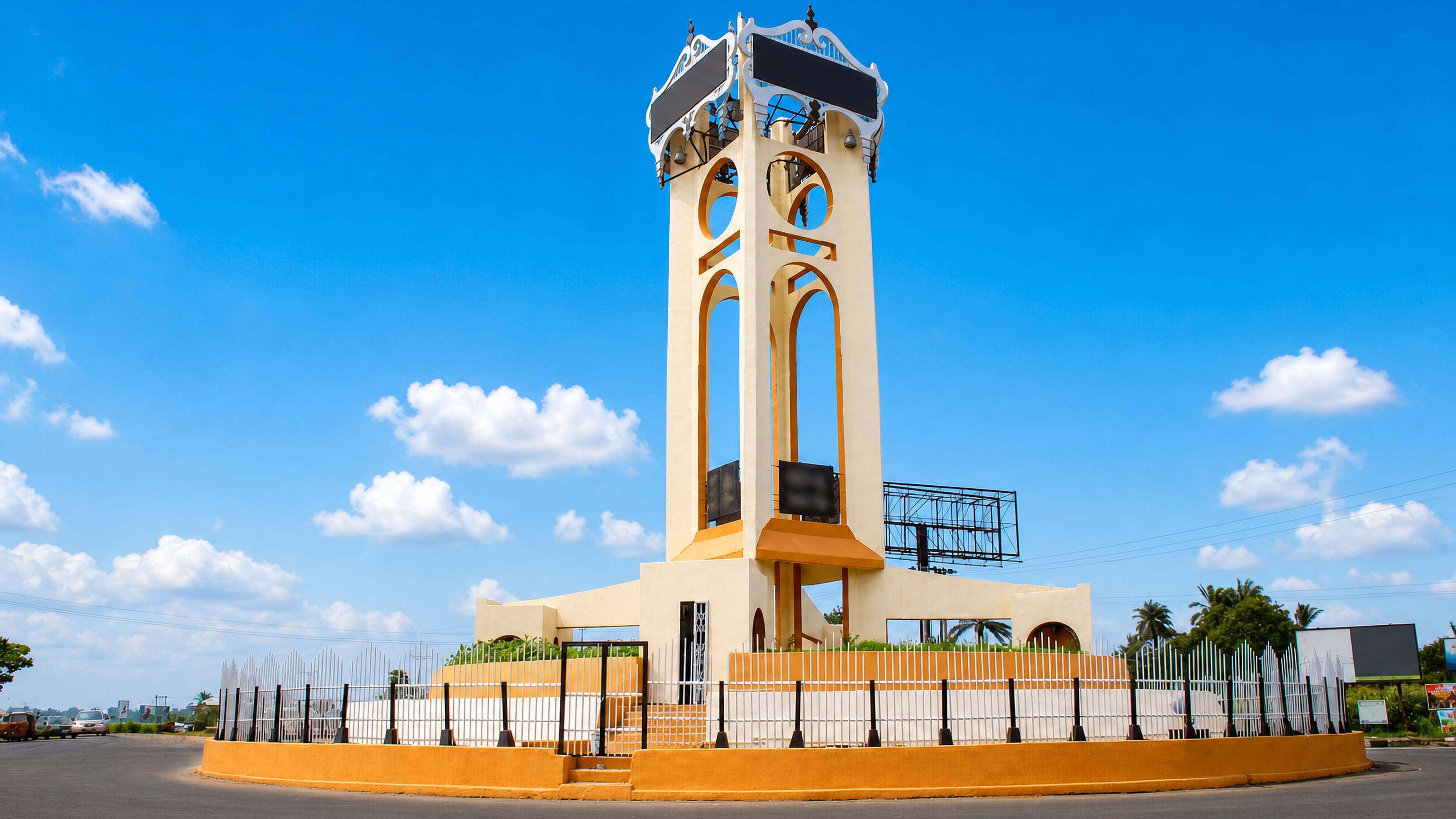 Umuahia's landmark clock tower monument on a landscaped roundabout under a bright blue sky, Abia State