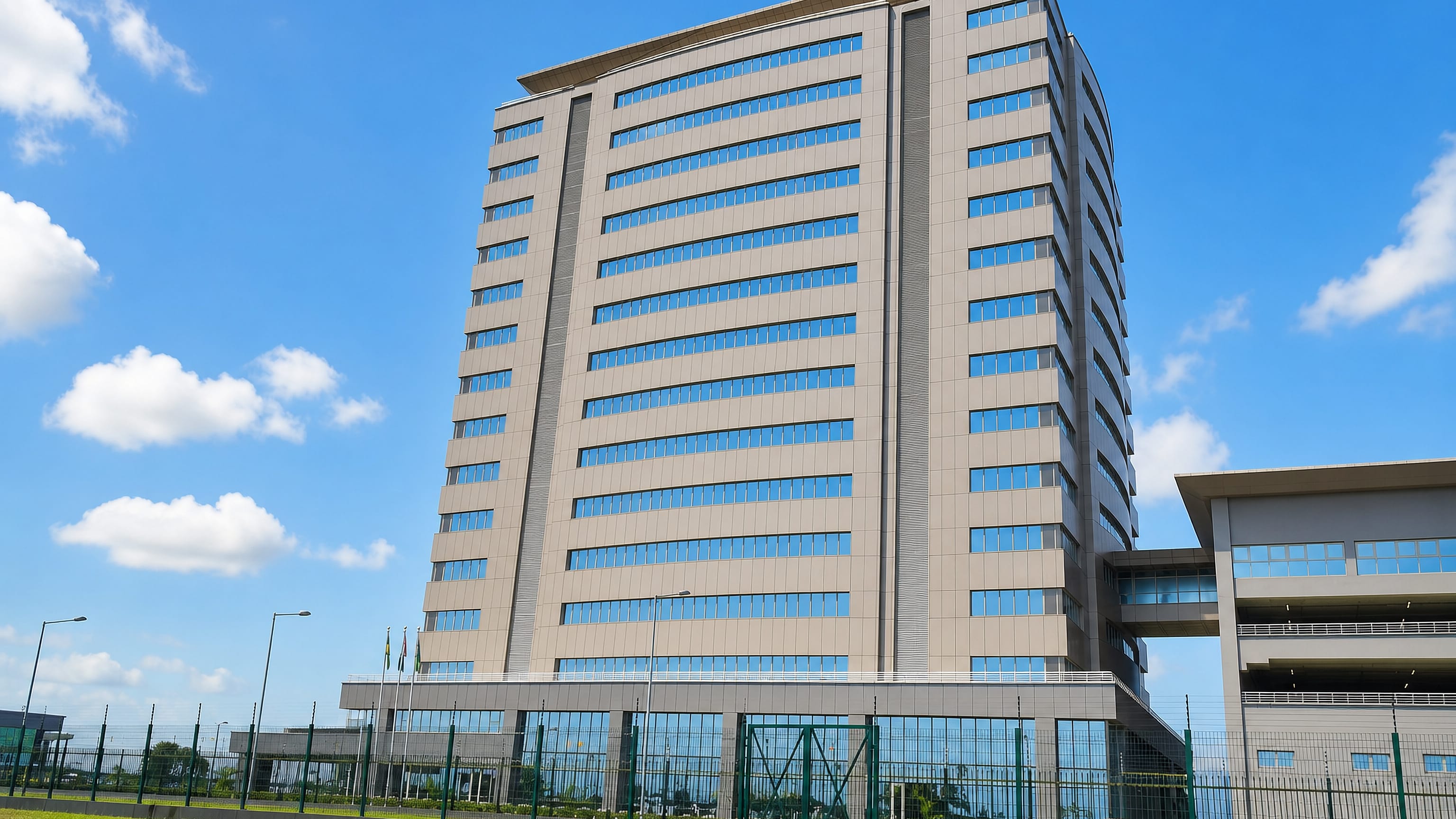 Modern mid-rise office tower behind perimeter fencing under a bright sky in Yenagoa, Bayelsa State.