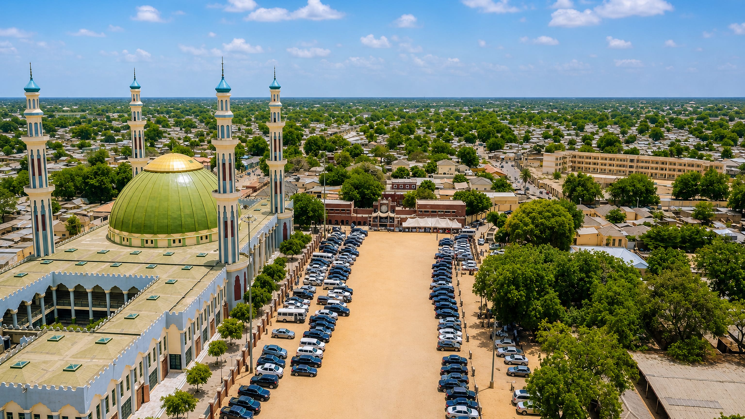 Green-domed central mosque with four minarets above the low sprawl of Maiduguri, Borno State, Nigeria.