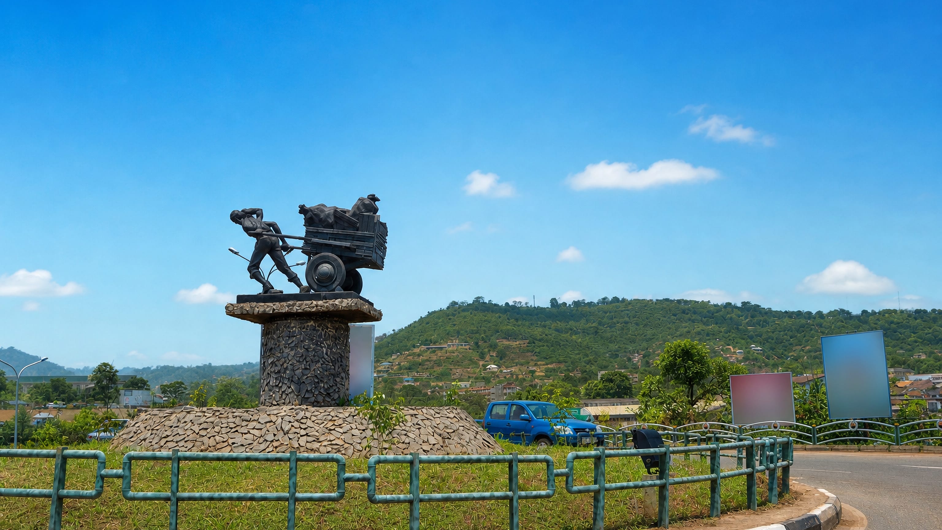 Coal miner monument on a landscaped roundabout with green hills behind in Enugu, Nigeria