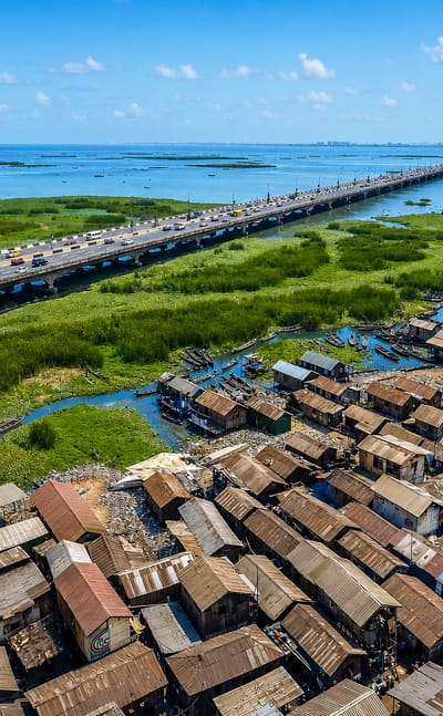 Aerial view of Lagos's Makoko stilt settlement of corrugated shacks beside the Third Mainland Bridge over the lagoon.