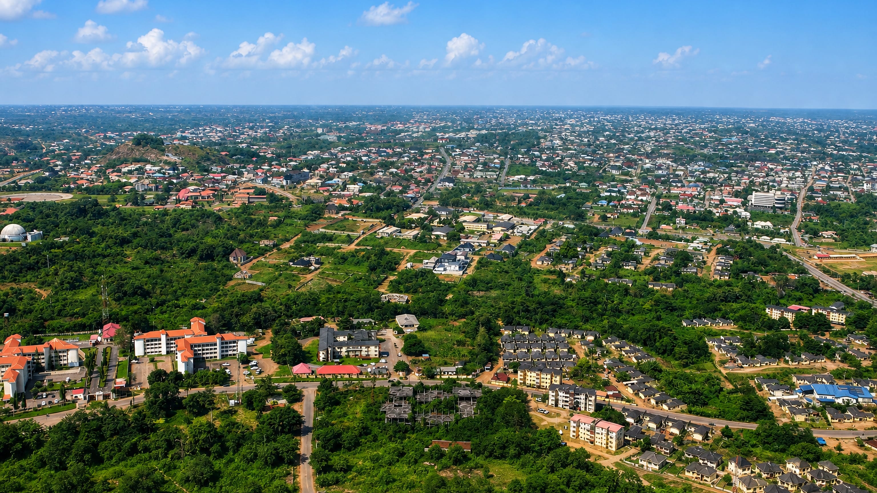 Aerial view over the green low-rise sprawl and rocky outcrops of Akure, capital of Ondo State.