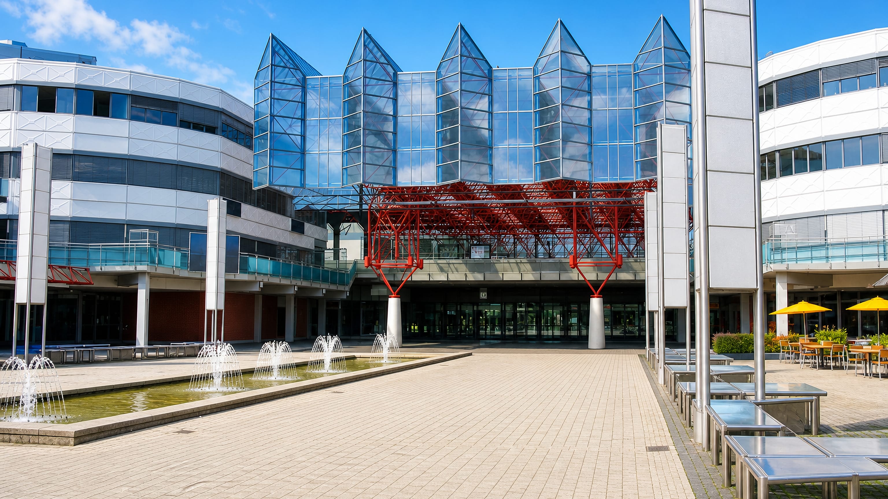 Fountains on the plaza in front of a glass-gabled civic building in the modern centre of Almere Stad.