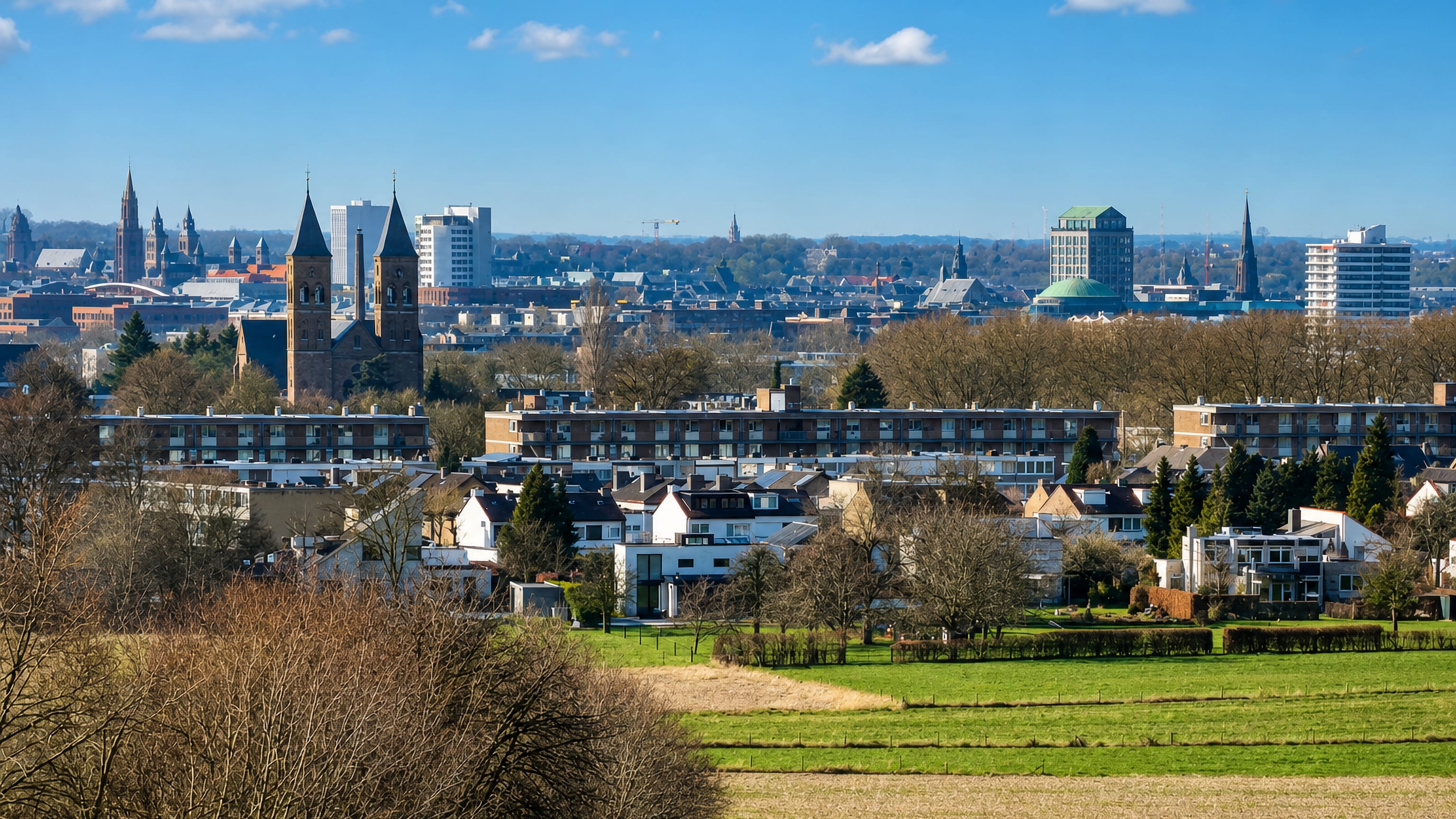 Maastricht's church towers and rooftops seen across farmland from the Heer district on the city's edge