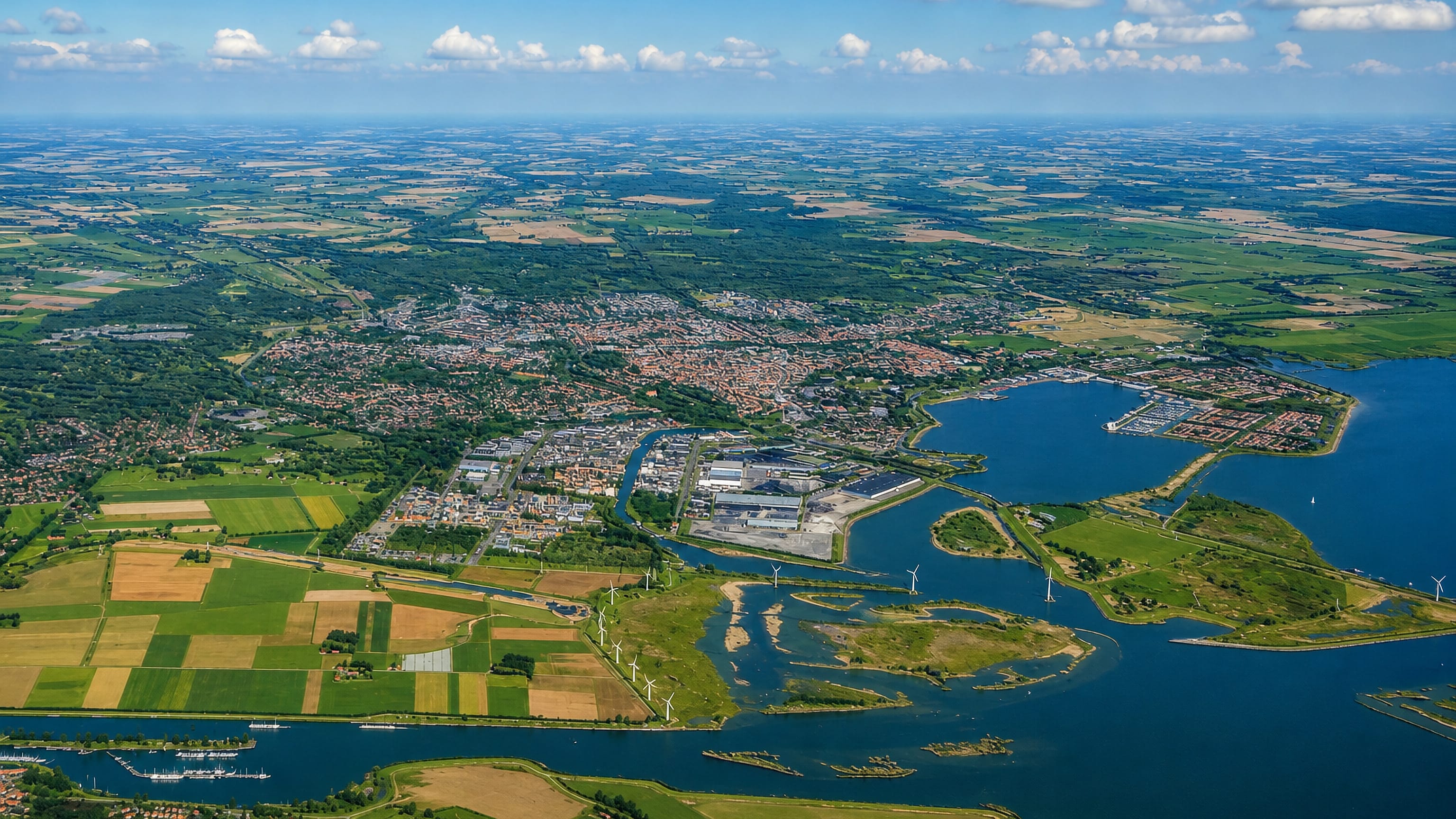 High aerial over Bergen op Zoom, Netherlands, its harbour, polder fields and the Oosterschelde waters.