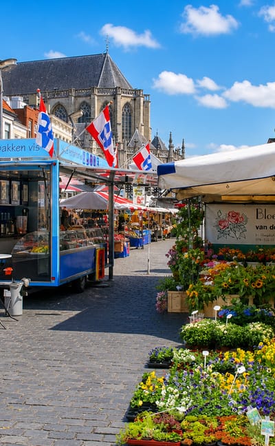 Flower and produce market stalls on Breda's Grote Markt below the Grote Kerk tower, Netherlands