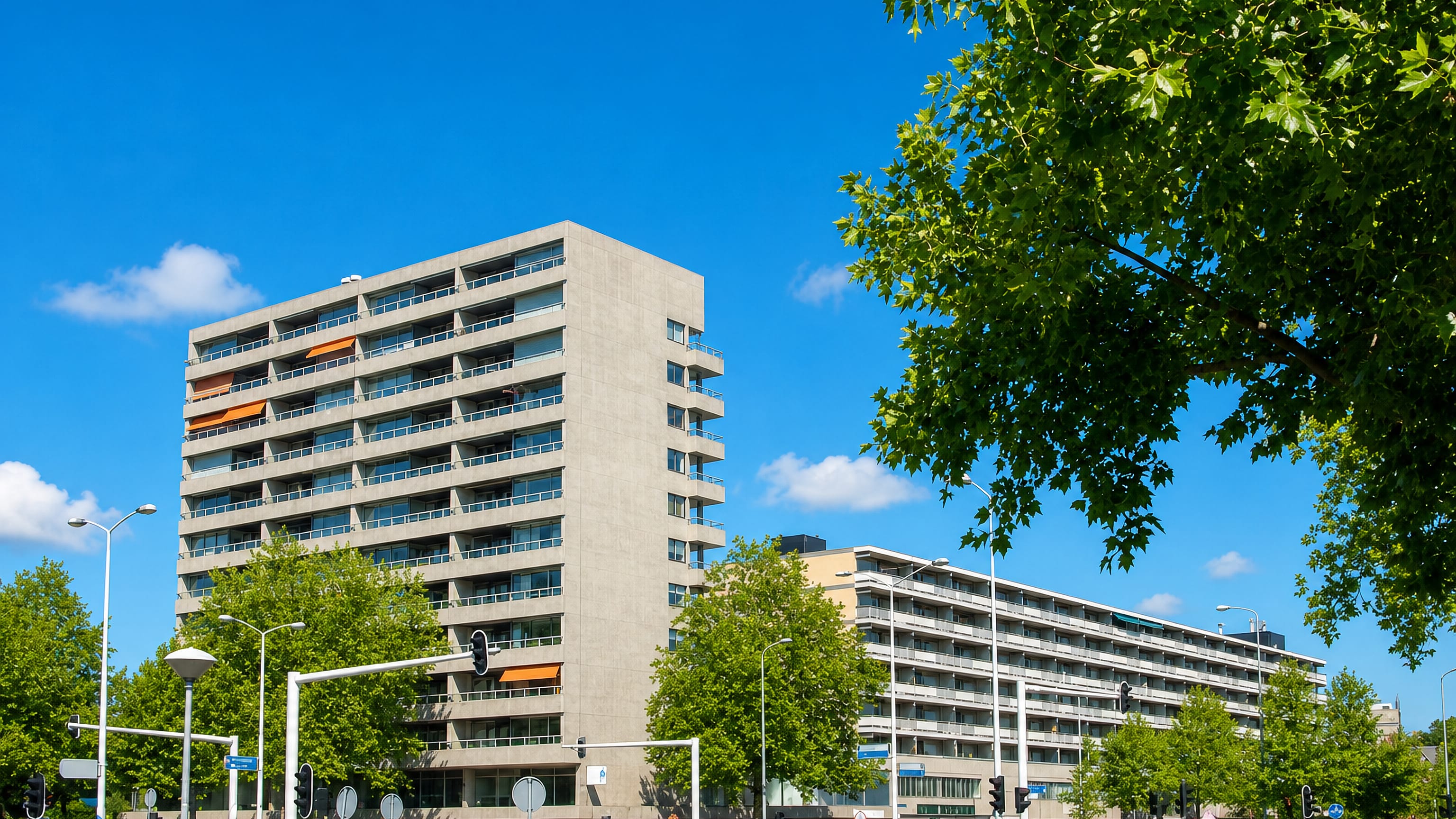 Modernist apartment tower and long gallery flats along a broad avenue in Stratum, Eindhoven