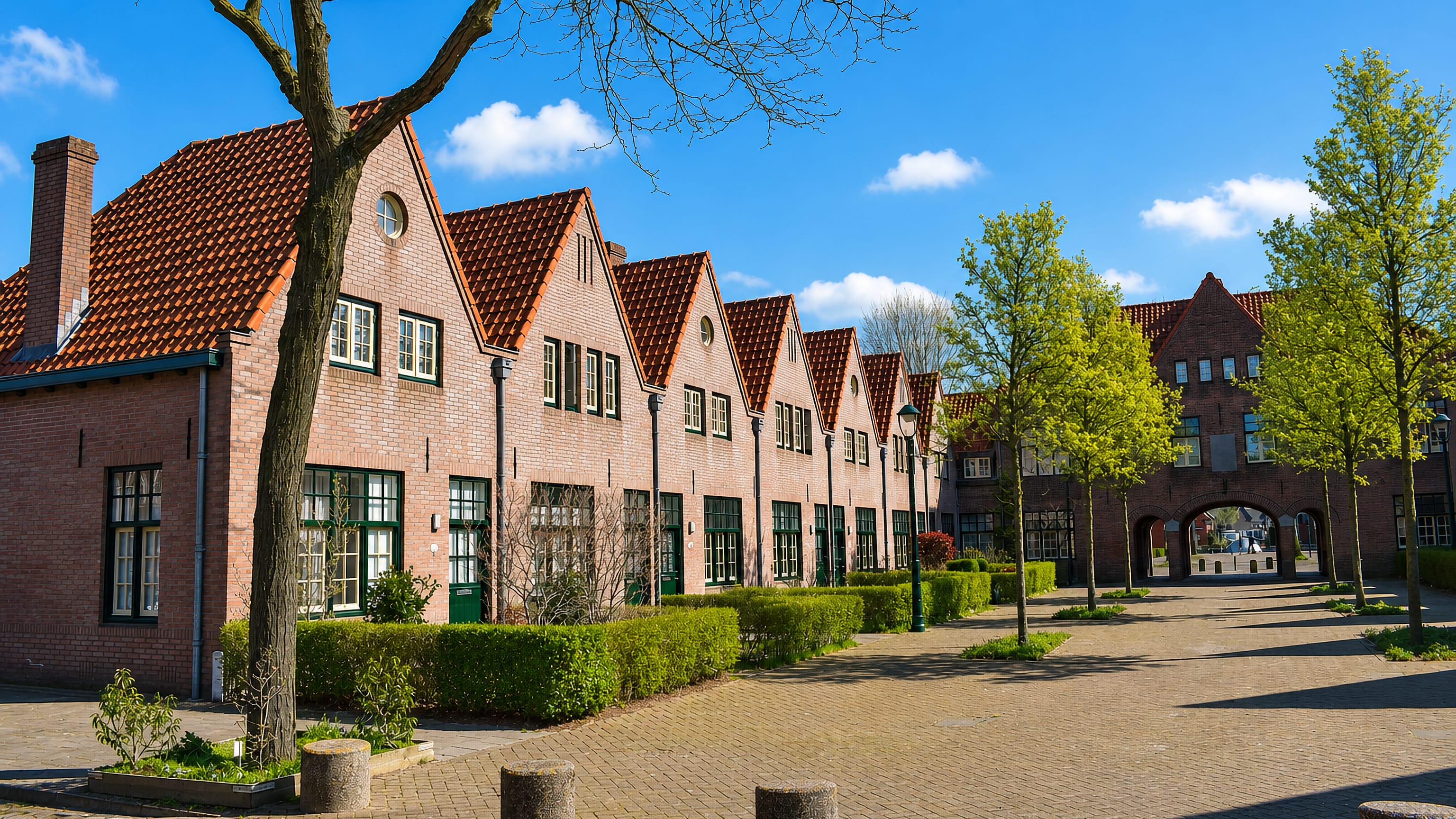 Row of stepped-gable brick houses around a brick courtyard in Tongelre, a residential district of Eindhoven.
