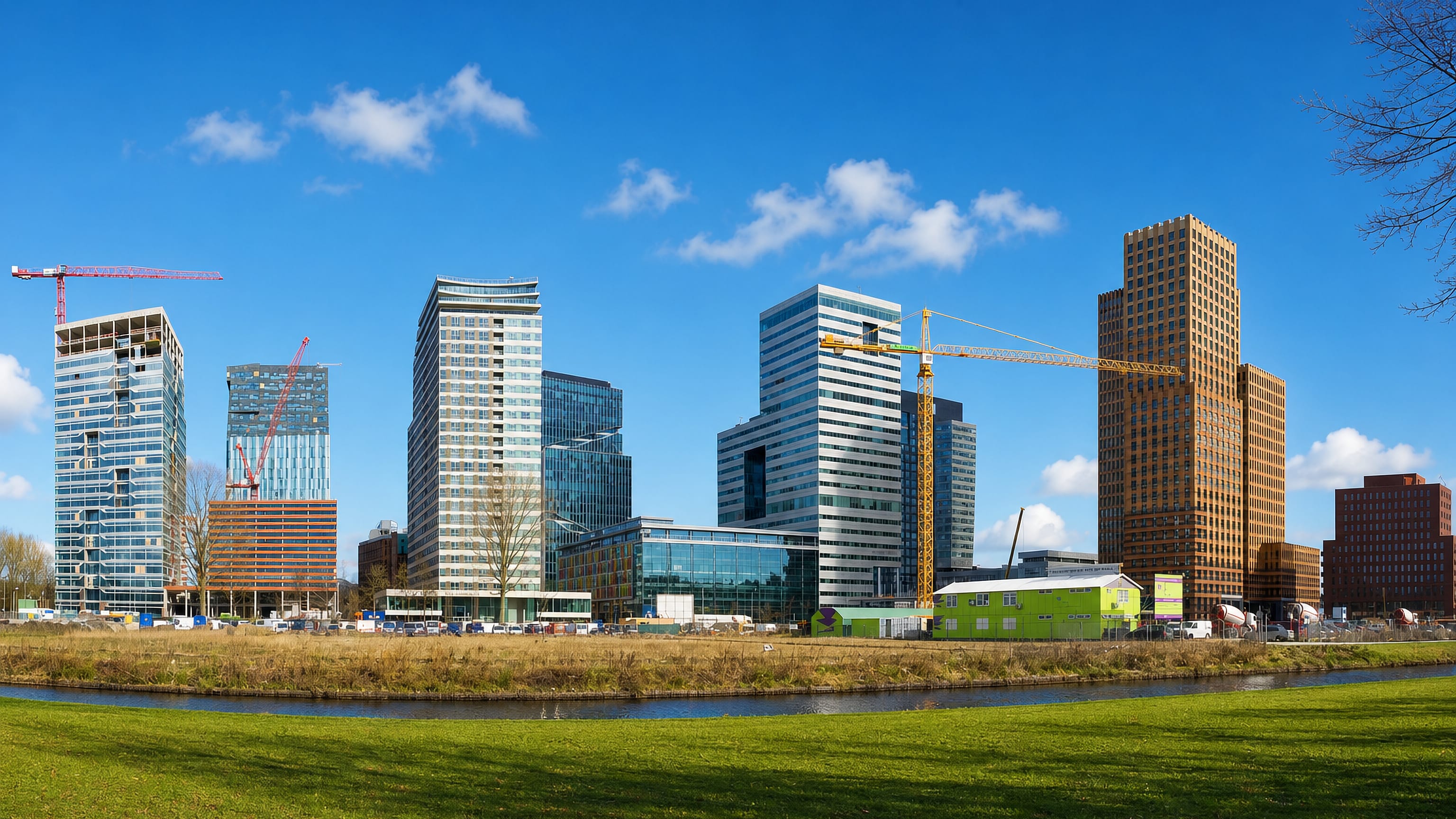 Zuidas high-rises and construction cranes above a canal in Amsterdam-Zuid