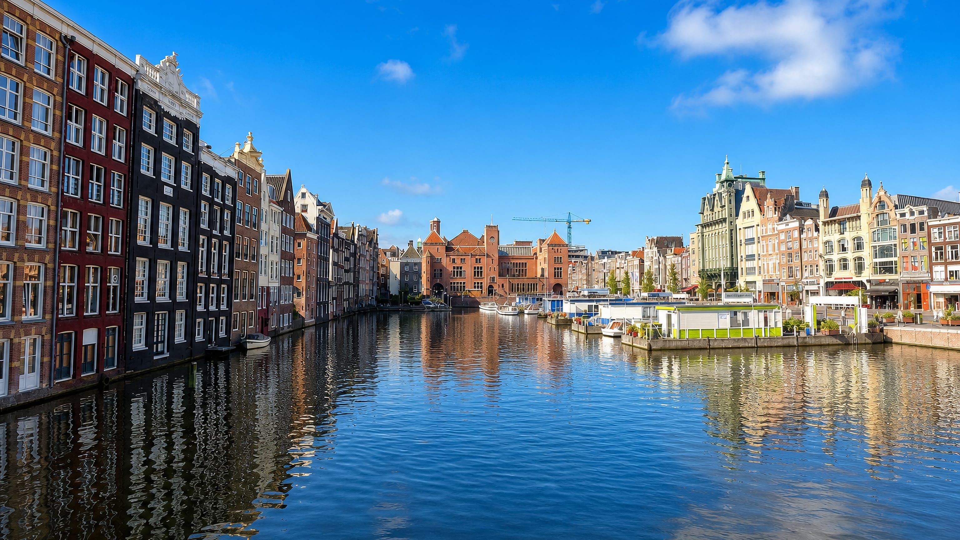 Canal houses lining the Damrak waterway beside Amsterdam's De Wallen old-centre district.
