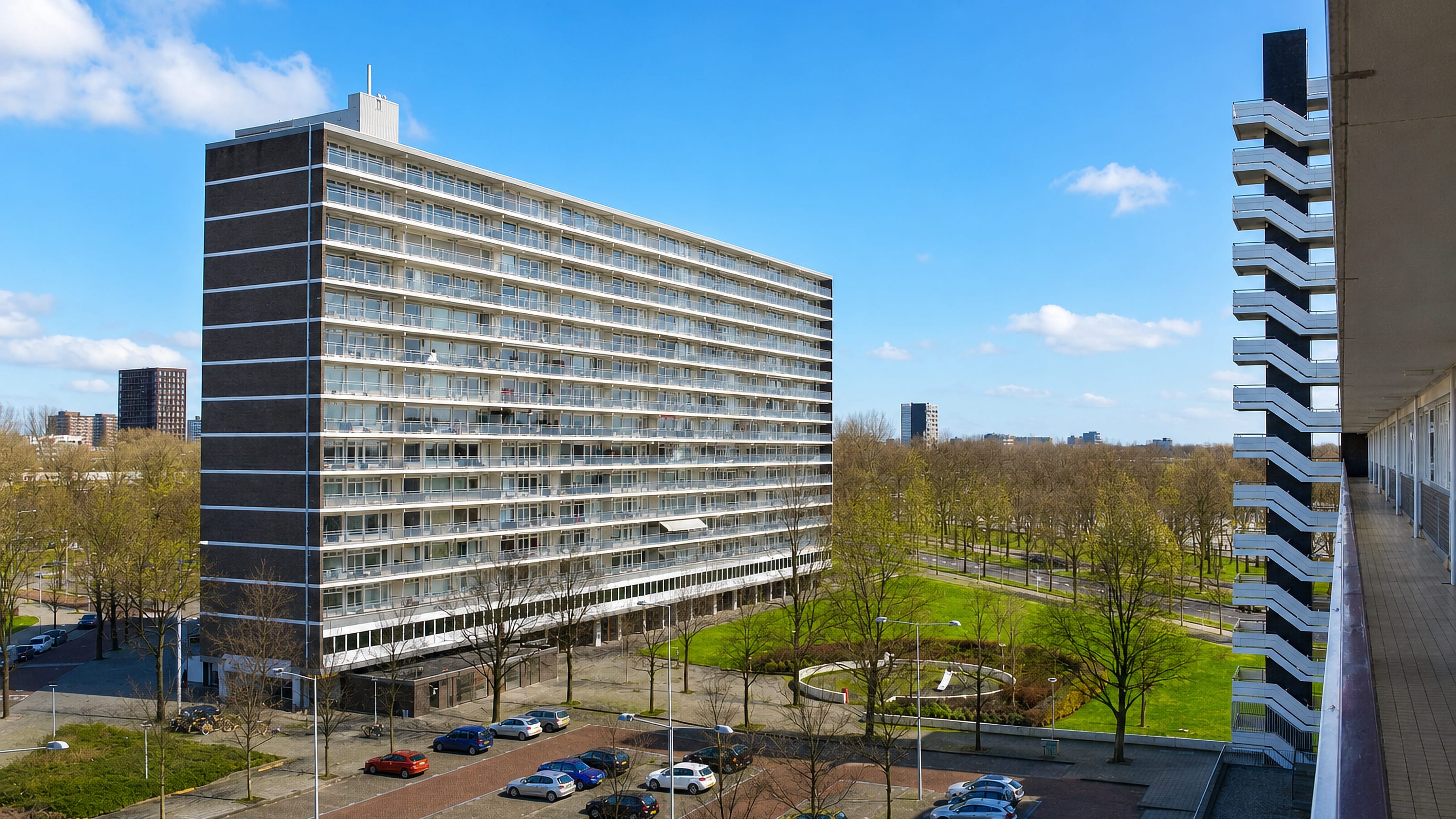 Long post-war gallery-flat block and open lawns under a blue sky in Slotermeer, Amsterdam Nieuw-West.