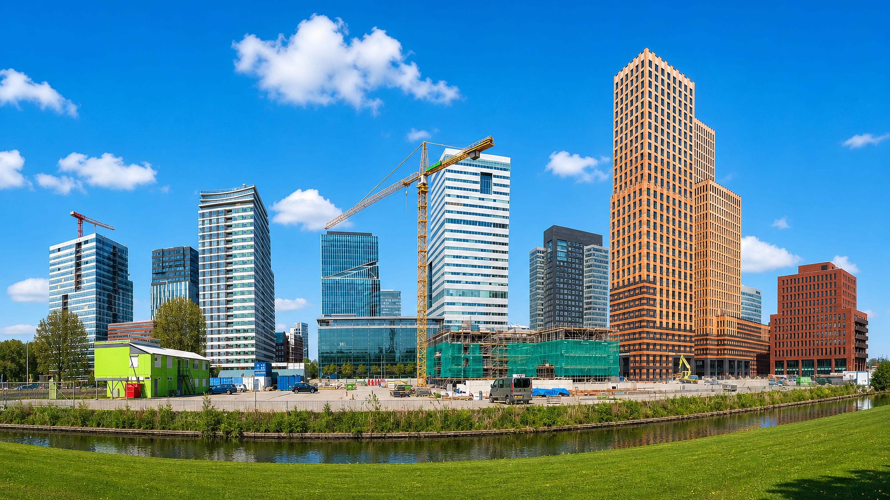 The Zuidas business district skyline in Amsterdam seen across a canal and lawn