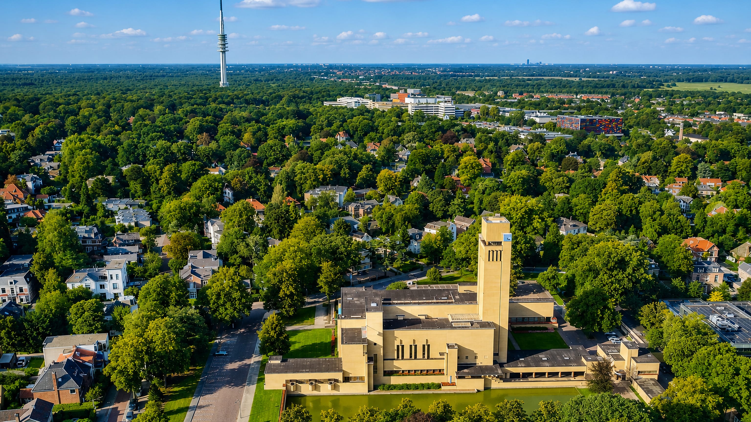 Hilversum's Dudok town hall with its brick tower and reflecting pond, backed by leafy suburbs and a TV mast.