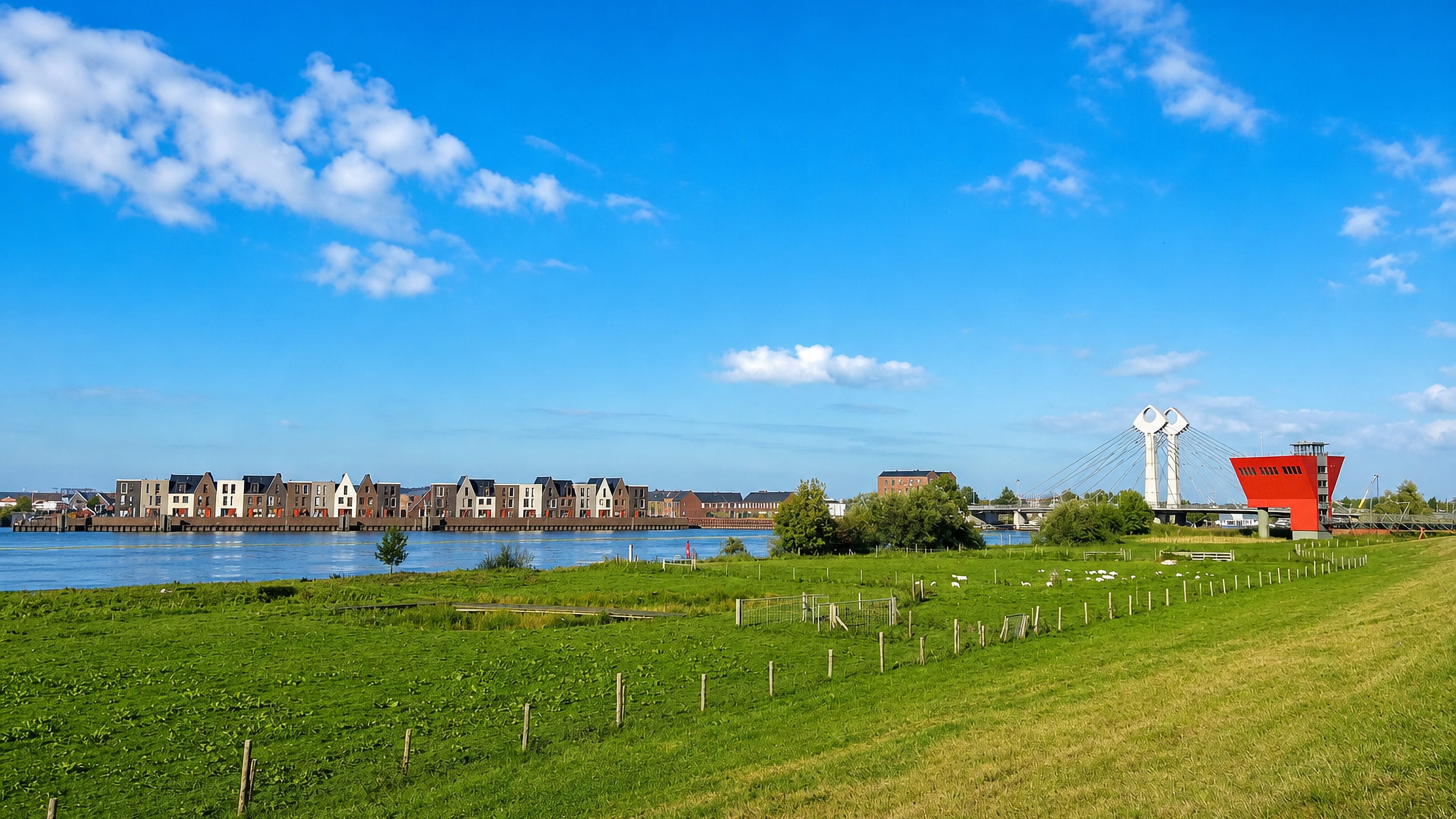 Stadshagen's waterfront houses across the water in Zwolle, seen from a grassy dike with a cable-stayed bridge