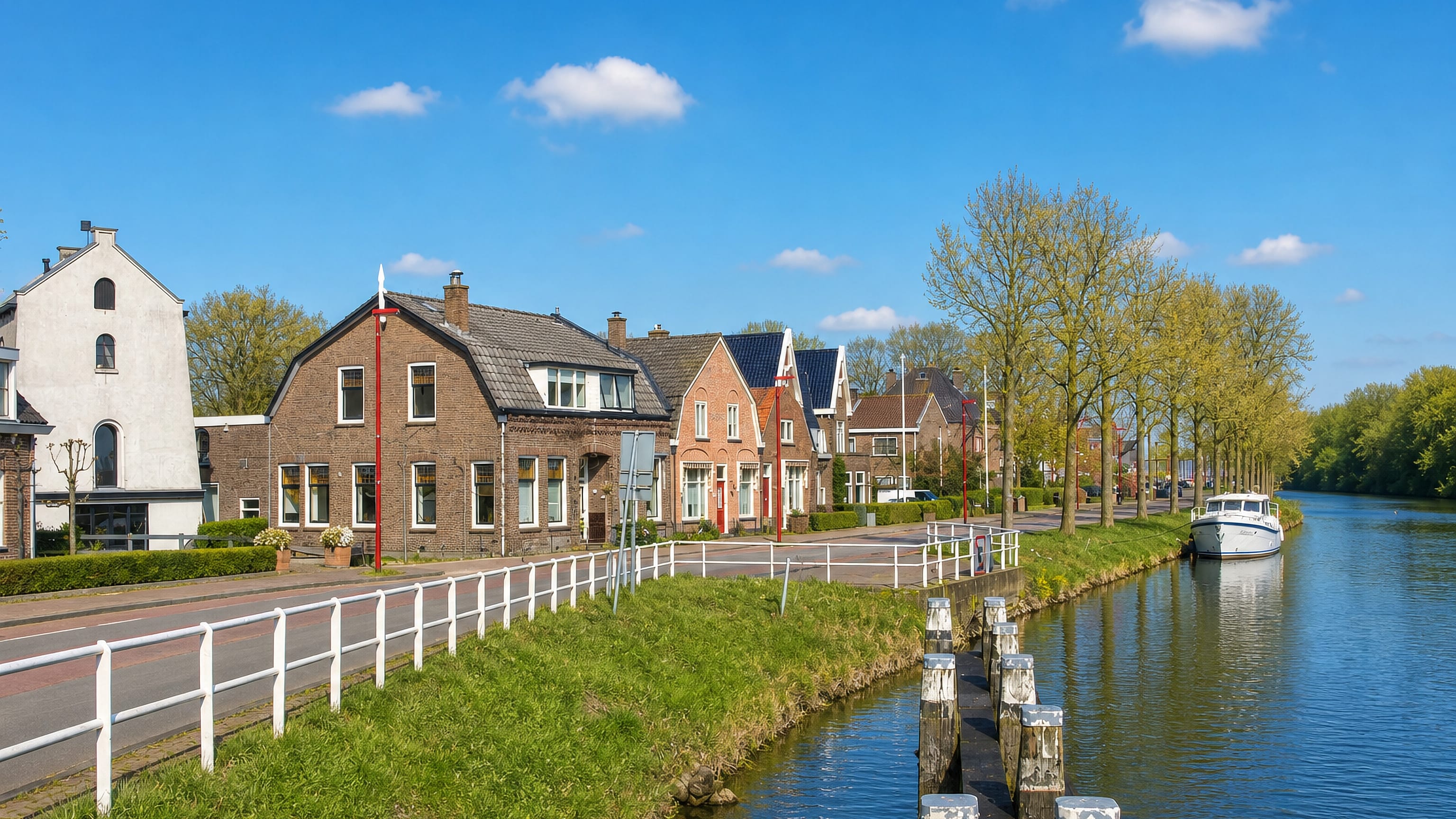 Brick canal-side houses and a moored cruiser along the water at Jutphaas, Nieuwegein