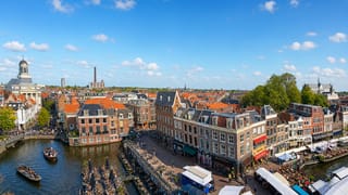 Leiden's Nieuwe Rijn canal lined with historic gabled houses, cafe terraces and boats.