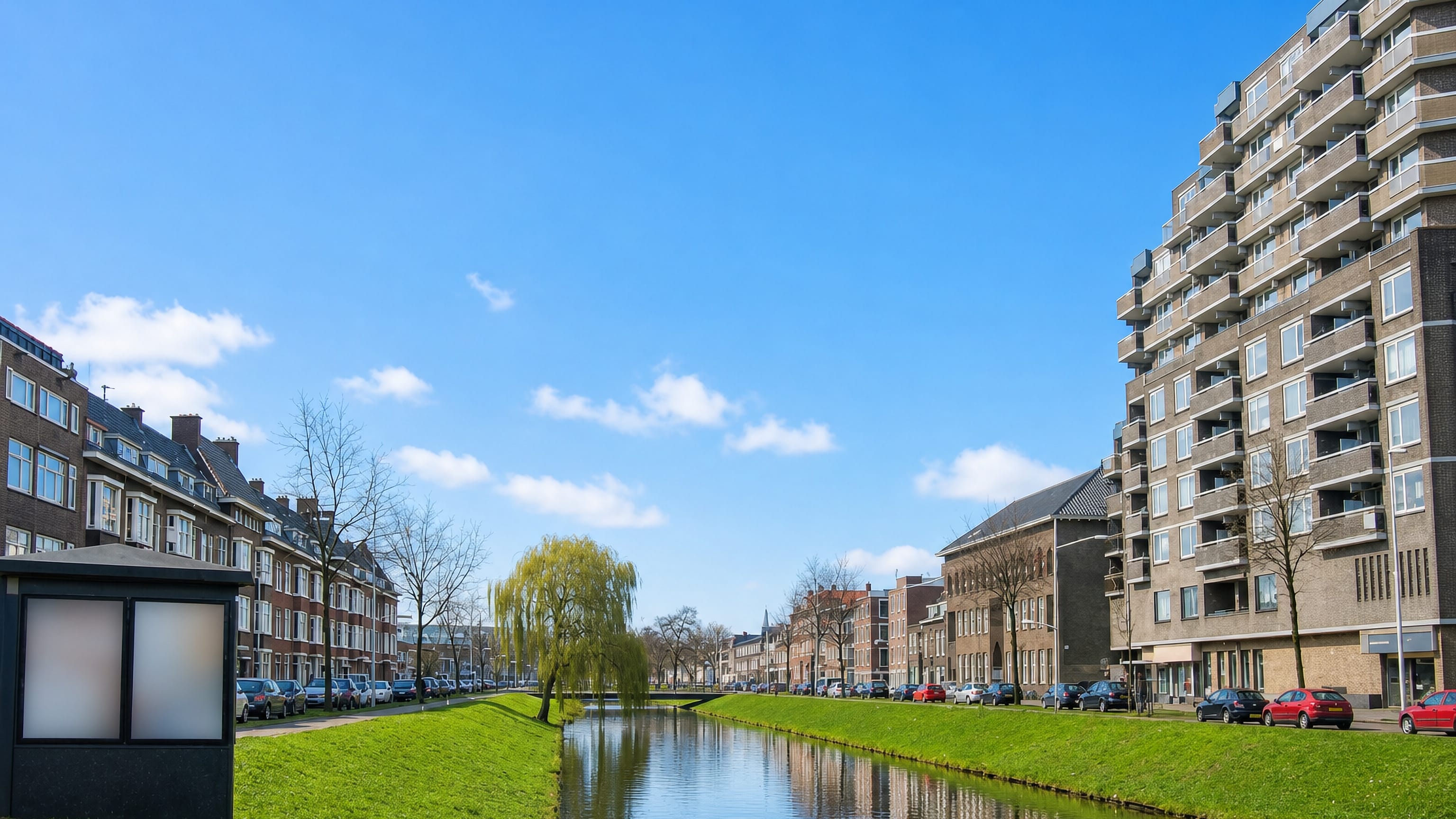 Canal lined with brick terraces and a post-war apartment block in Feijenoord, Rotterdam-Zuid.