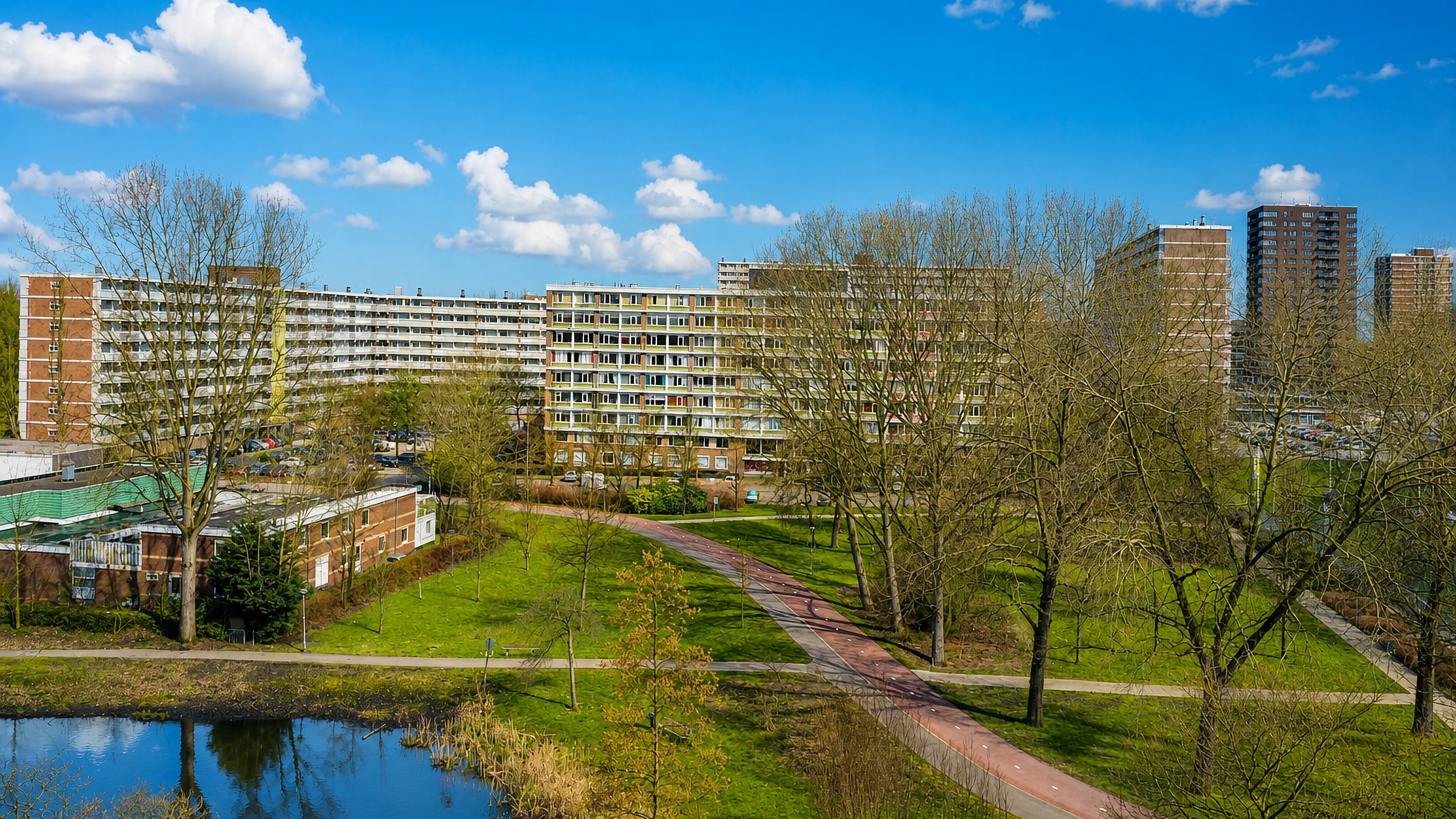 Slab apartment blocks and towers above the park, pond and cycle path of Ommoord, Rotterdam