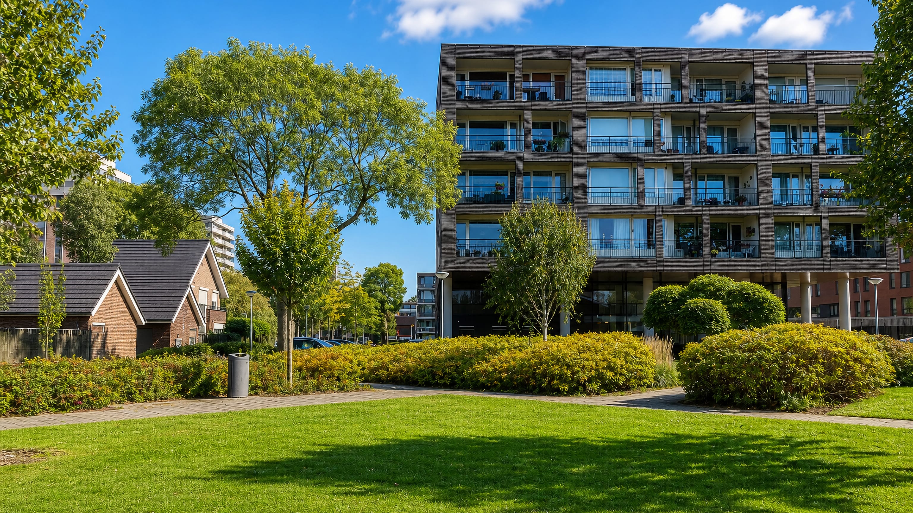 Modern brick apartment block above a lawn and shrub borders in Zalmplaat, Rotterdam.