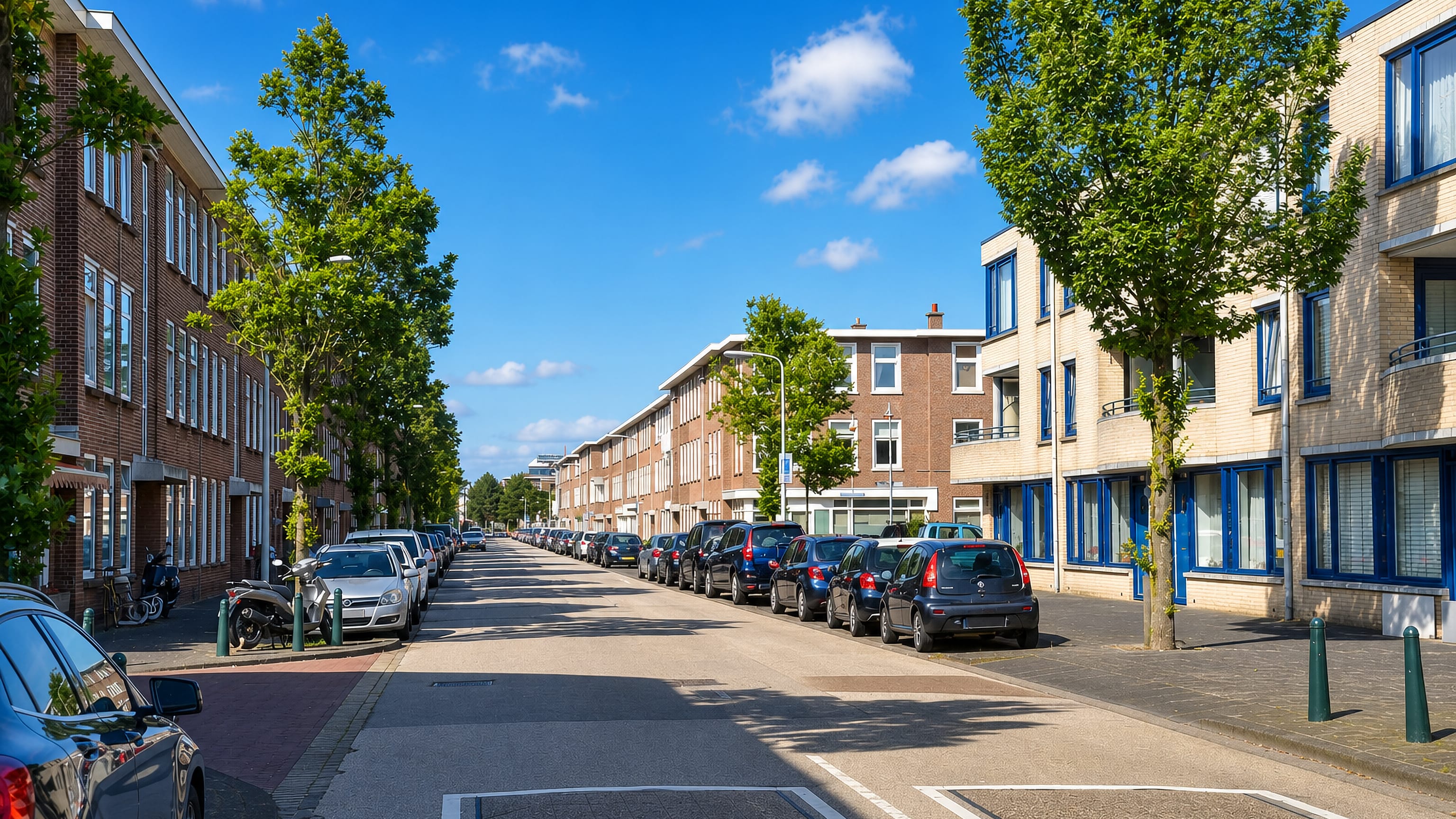 Brick terraced houses and parked cars lining a quiet residential street in Duindorp, The Hague.