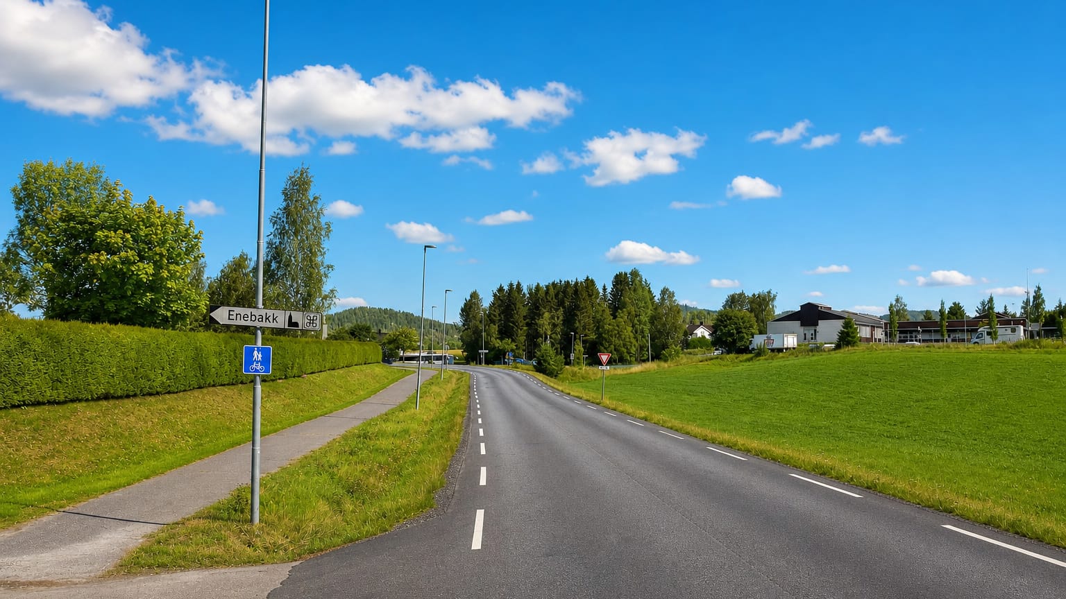 An empty rural road with an Enebakk signpost and green fields near Kirkebygda, Norway.