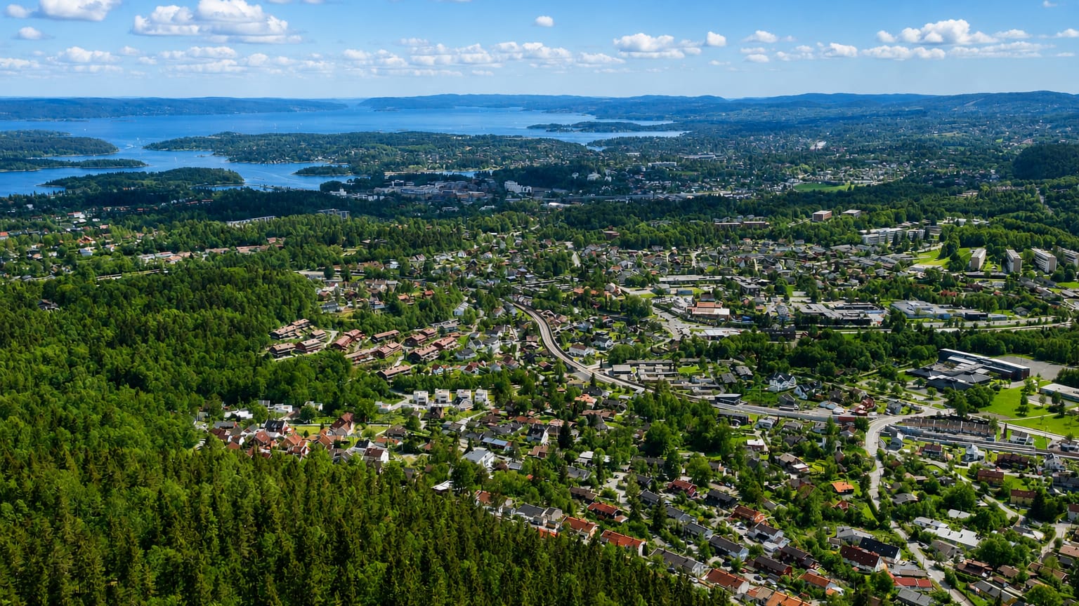 Aerial view of the leafy Sandvika suburbs with the Oslofjord and its islands beyond, Norway