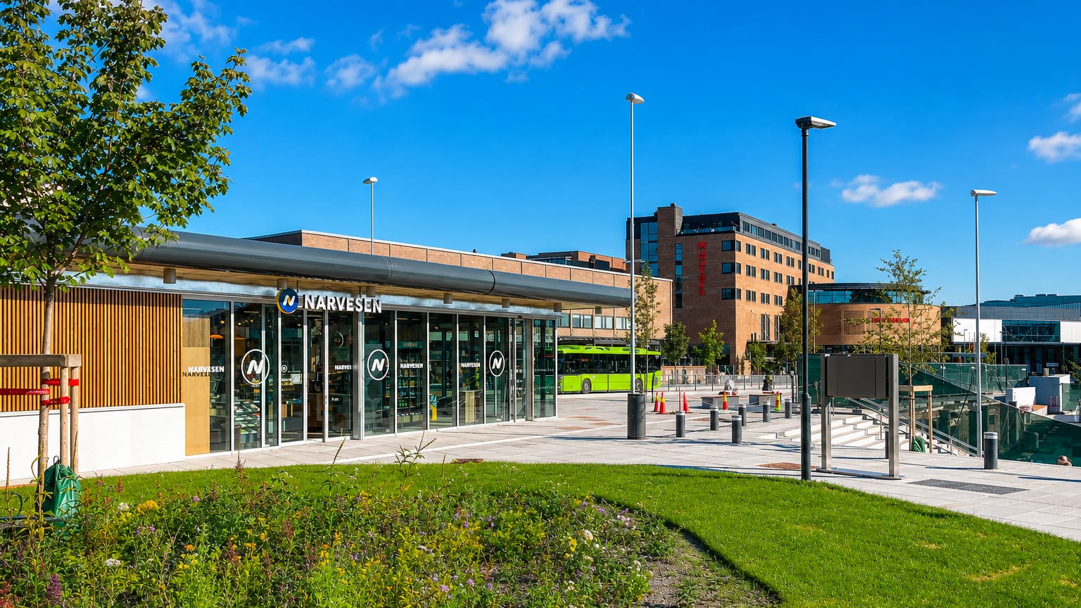 Modern town-centre plaza with a Narvesen kiosk, a green city bus and a brick office block in Ski, Norway.