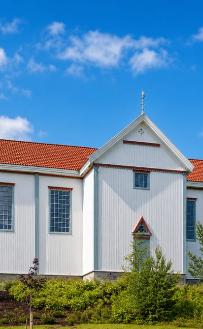 White timber church with a tall steeple and red-tiled roof at Prestfoss in Sigdal, Buskerud, Norway.