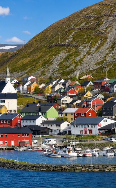 Kjøllefjord, Norway, a colourful Arctic fishing village and harbour below a bare Finnmark mountain.