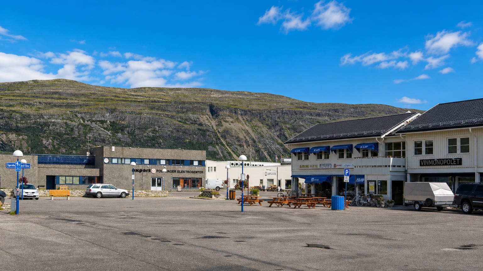 Town-square shops beneath a bare Finnmark mountain in Lakselv, northern Norway.