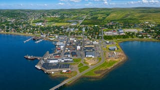 Aerial view of Vadso on its harbor peninsula with the Vadsoya bridge and Finnmark hills, Norway.