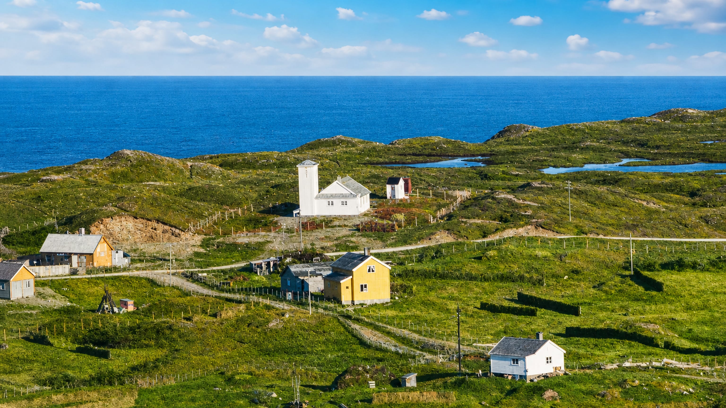 Coastal hamlet of Vuonnabahta, Norway, with white and yellow houses on green tundra above a deep-blue sea.