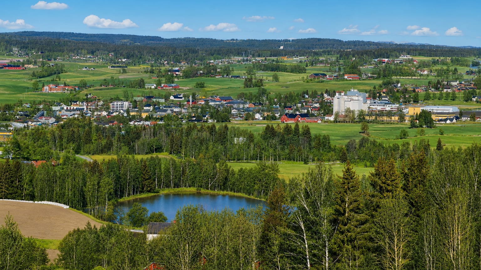 Elevated summer view over Lena, Norway, a small town amid the farmland and forests of Toten.