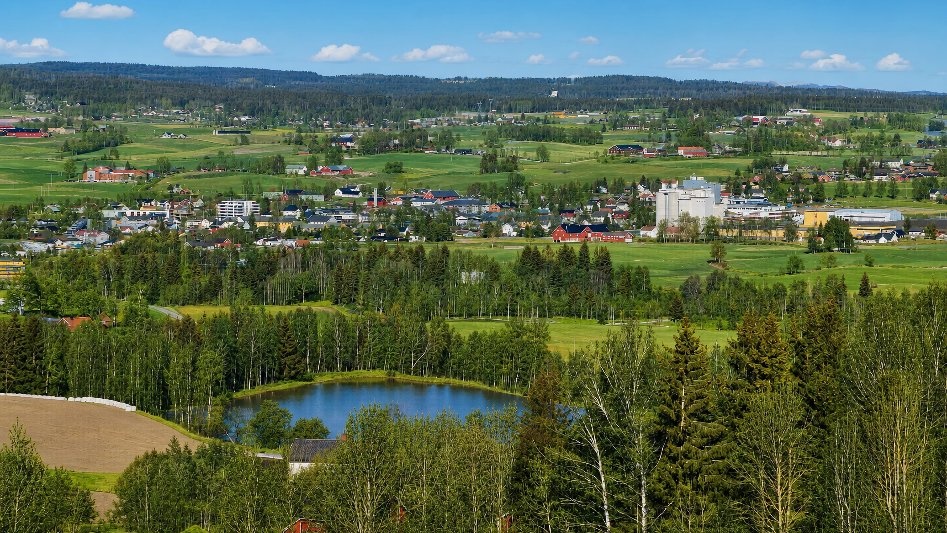 Elevated summer view over Lena, Norway, a small town amid the farmland and forests of Toten.