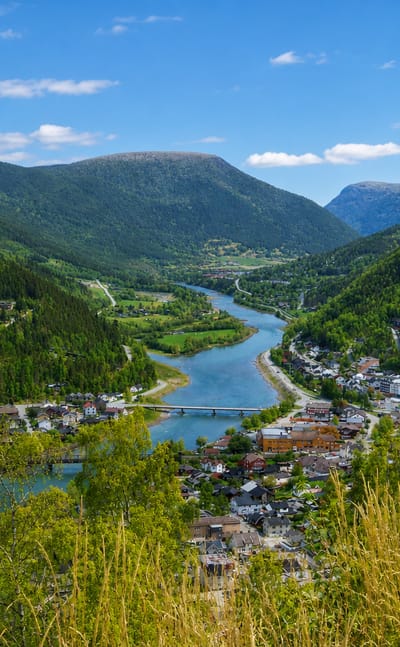 Otta town at the river confluence in the Gudbrandsdalen valley beneath green mountains, Innlandet, Norway