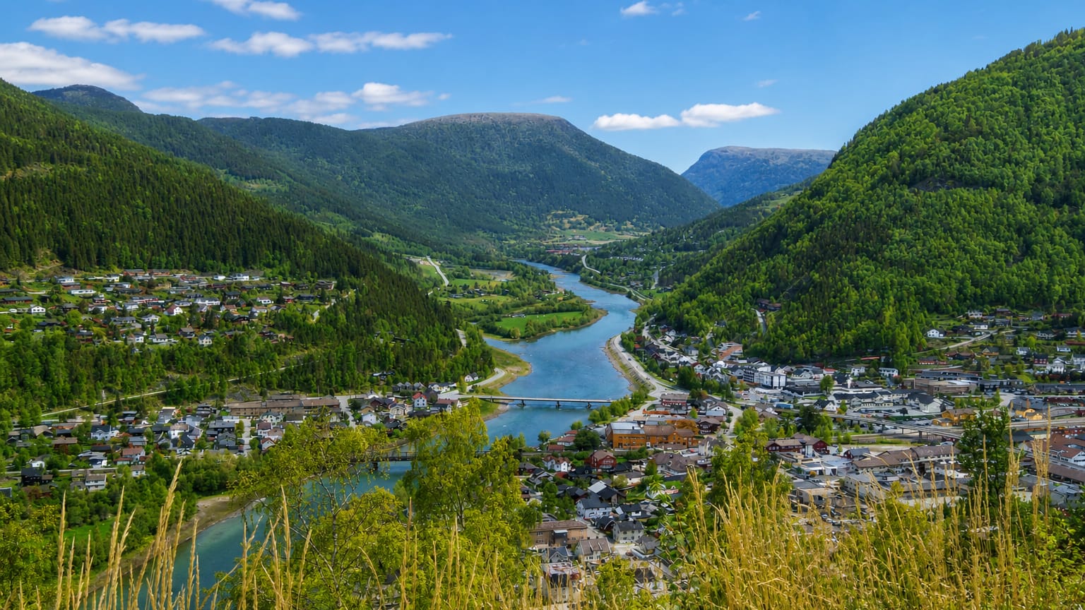 Otta town at the river confluence in the Gudbrandsdalen valley beneath green mountains, Innlandet, Norway