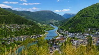 Otta town at the river confluence in the Gudbrandsdalen valley beneath green mountains, Innlandet, Norway