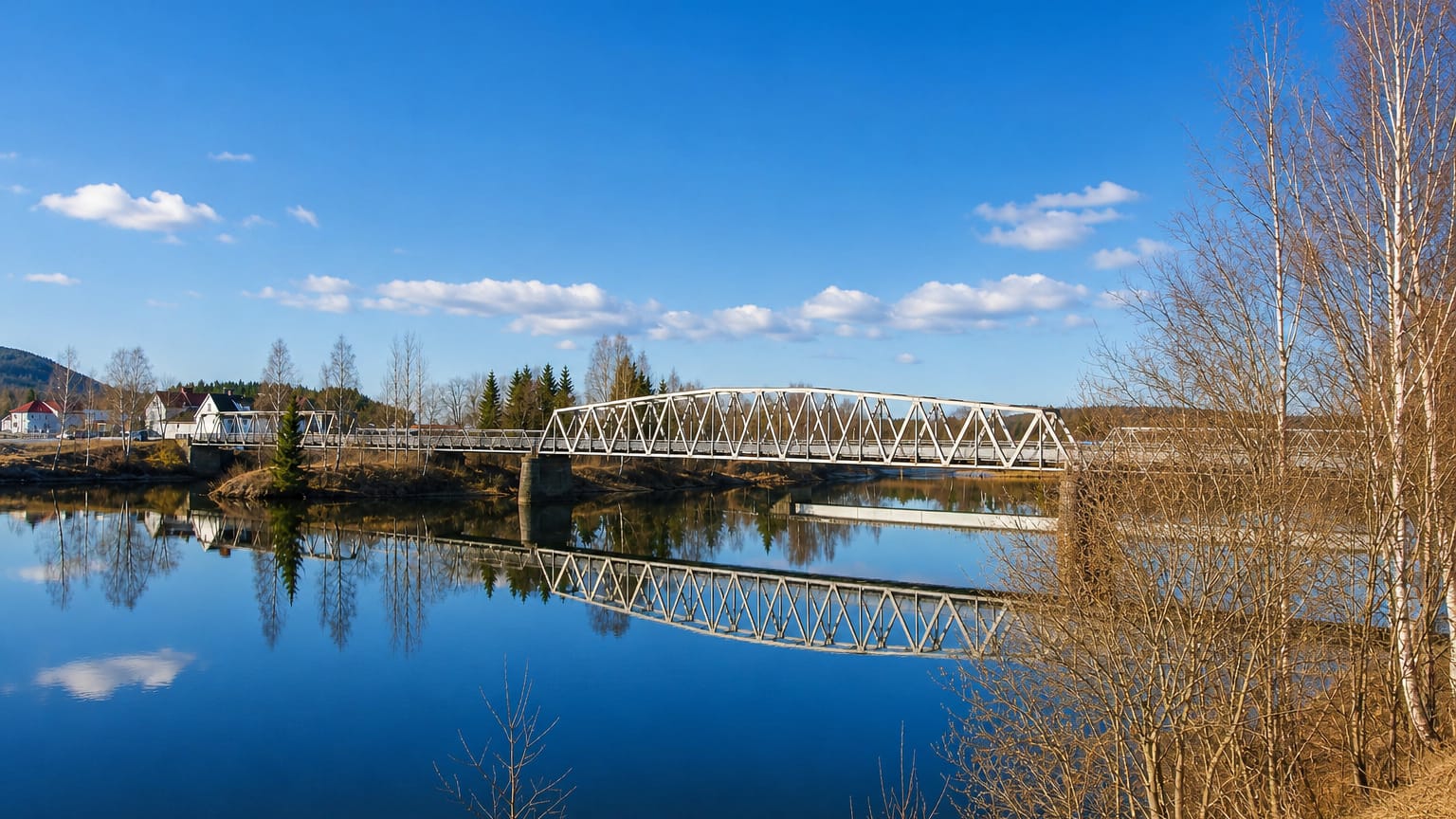 Steel truss bridge mirrored in the calm Glomma river at Skarnes, Norway, in early spring