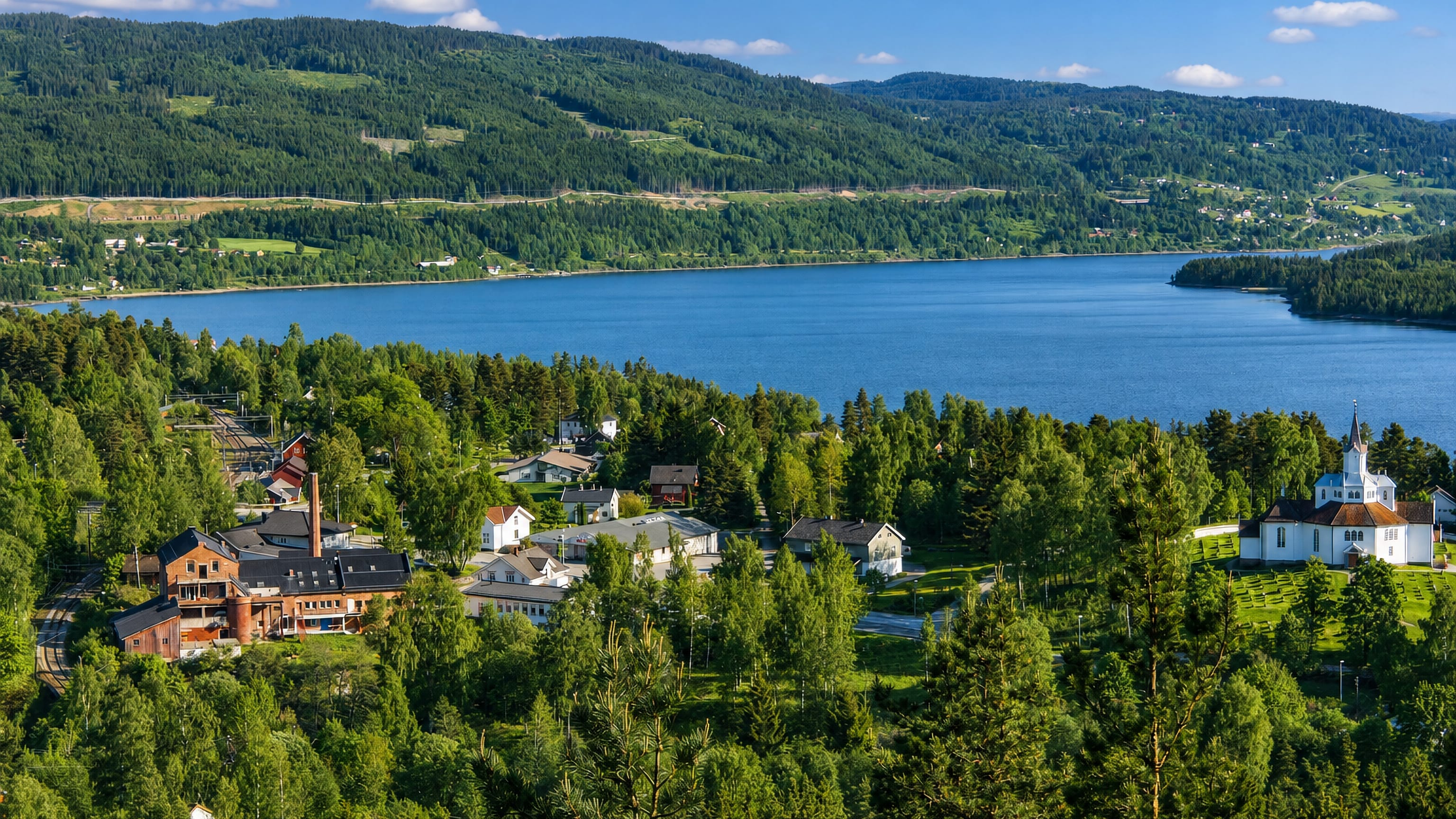 Lakeside village with a white church and old brick works among forest near Stange, Innlandet, Norway