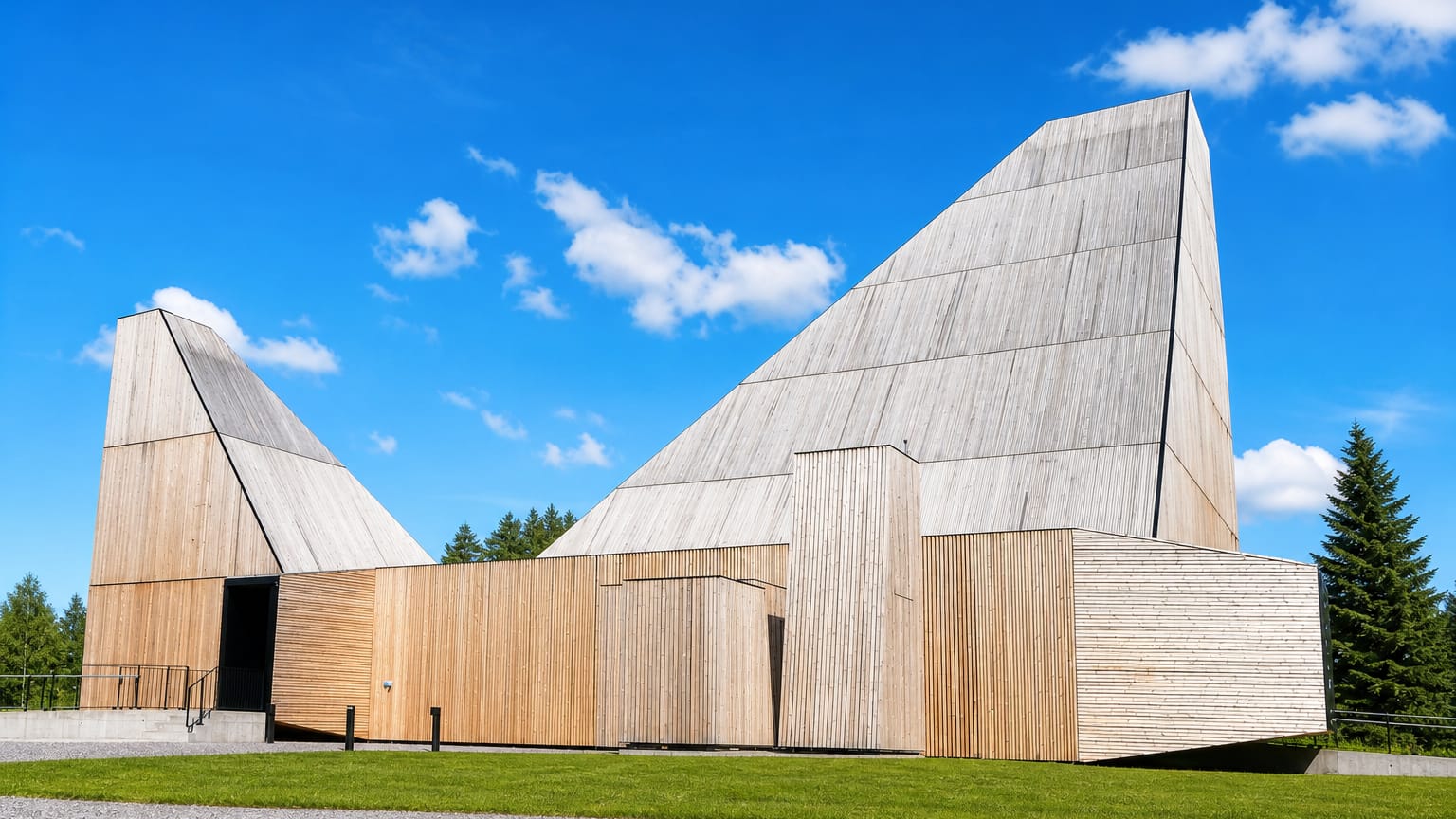 Våler's contemporary timber church with two soaring angular peaks clad in pale wood against a bright blue sky.