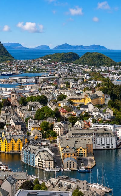Aerial view of Ålesund's Art Nouveau town spread across islands between fjord waters and green mountains