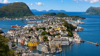 Aerial view of Ålesund's Art Nouveau town spread across islands between fjord waters and green mountains