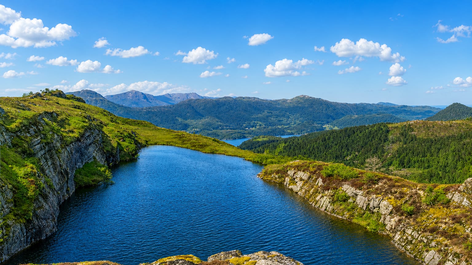 A mountain lake and fjord landscape with distant peaks near Aure, Møre og Romsdal, Norway.