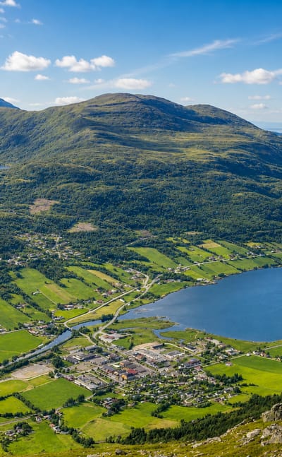 Batnfjordsøra at the head of Batnfjorden, surrounded by green farmland and forested mountains, Møre og Romsdal, Norway